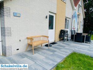 Ferienhaus außen 11 Westterrasse mit Kohlegrill Sitzbank Gartenmöbeln und Surfbrett - Ferienhaus aussen - Schakelvilla mit Sauna in Makkum am IJsselmeer