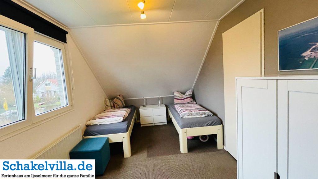 Schlafmöglichkeiten in der Schakelvilla 4 zwei Einzelbetten 80x200 cm im Schlafzimmer zum Parkplatz - Schakelvilla Ferienhaus in Makkum am IJsselmeer