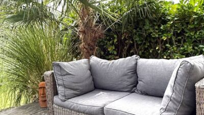 Gemütliche Lounge-Couch mit Korbgeflecht-Rahmen im Garten der Schakelvilla in Makkum